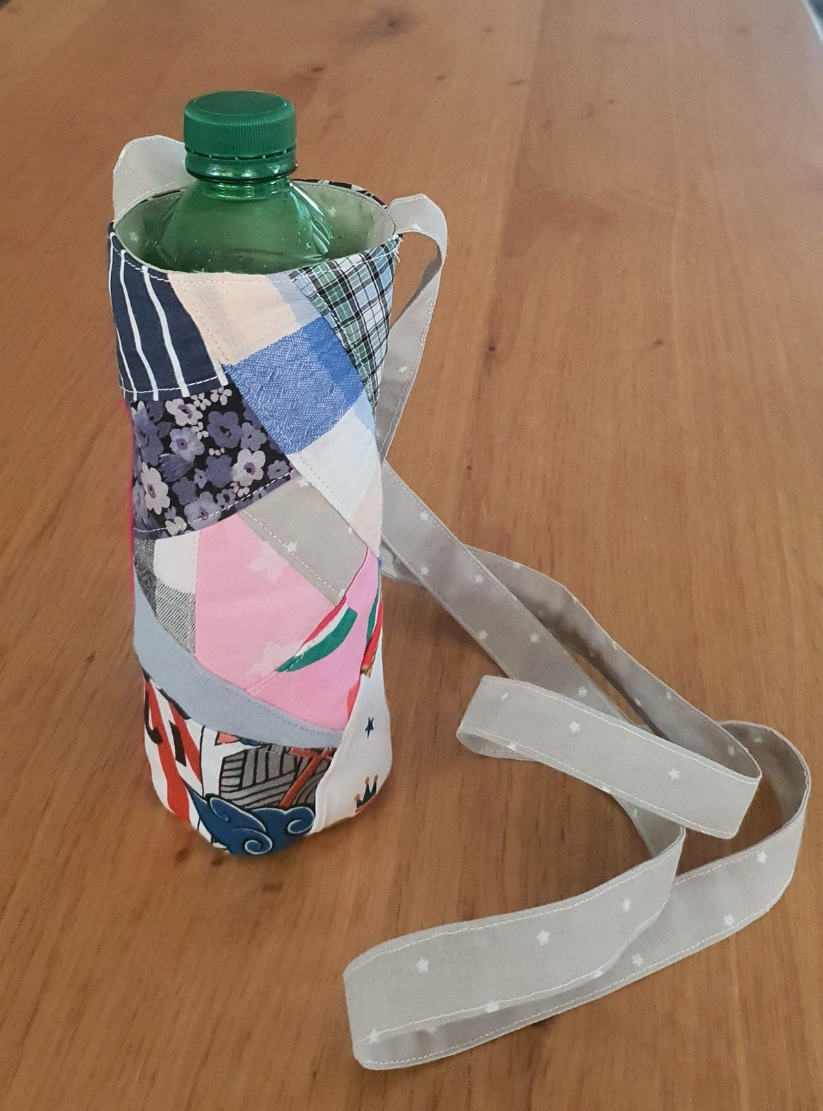 Lillys Kreativwelt handgefertigte Patchwork-Flaschentasche aus Stoff mit verstellbarem Trageriemen auf Holztisch